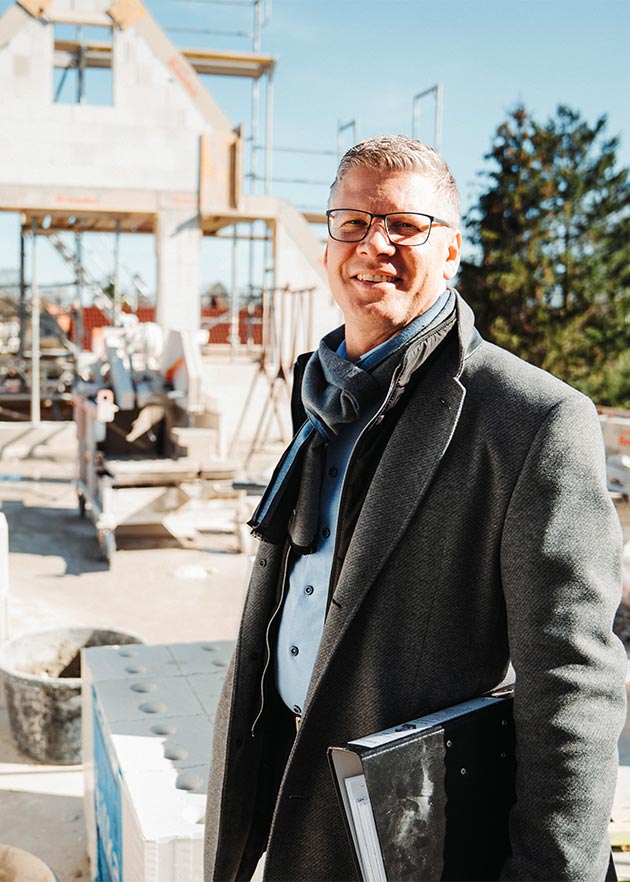 Erfahrener Bauleiter auf der Baustelle berät zu typischen Fehlern bei Anbau und Umbau